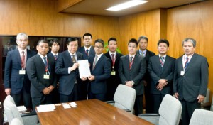 礒崎陽輔農水副大臣（左）に要請書を手渡し、産地支援の維持を訴えた菅野淳也委員長（中央）ら＝２０日、農林水産省