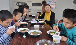 町内各飲食店の創作どんぶり料理を味わう人たち＝２３日、和泊町