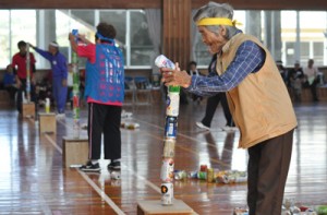 慎重に空き缶を積み上げる参加者＝５日、和泊町