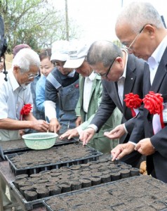 種の植え付けを行う吉玉会長ら（写真左）＝１３日、伊仙町伊仙