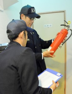 消火器の有効期限を確認する消防職員＝２２日、奄美市名瀬