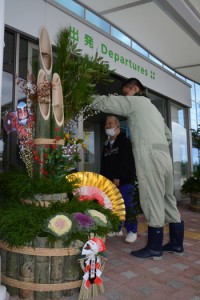 門松を設置する施設利用者＝２６日、奄美空港