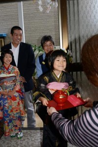 親戚宅でナンカンジョセを受け取る内野灯ちゃん＝７日、奄美市名瀬