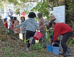 バケツリレーで消火用の水を運ぶ地域住民＝２１日、奄美市笠利町笠利