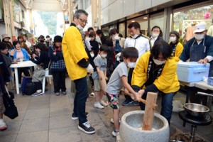 大人の助けも借りながら、餅つきに挑戦する子どもたち＝１７日、奄美市名瀬