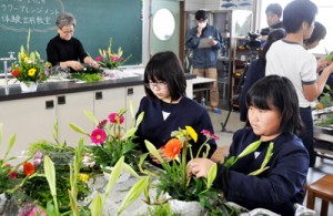 フラワーアレンジメントを通して地元産の花の魅力などを学んだ体験教室＝９日、和泊町の大城小学校