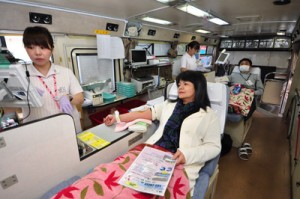 県赤十字血液センターのバス内で献血に協力する住民ら＝１６日午後、奄美市住用町