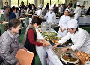 感謝の気持ちを込めて保護者らに料理を提供した学生たち（右）＝９日、奄美看護福祉専門学校