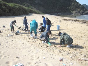 手作業で油の除去作業を行う参加者＝１４日、瀬戸内町与路島