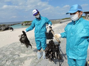 漂着油が絡んだ漁網を回収する参加者＝９日、喜界町のスギラビーチ