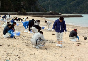 漂着油の回収作業に汗を流す奄美市職員＝９日、朝仁海岸