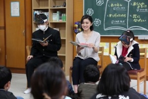 原口さんと一緒に朗読する児童生徒＝１月３１日、名柄小中（提供写真）