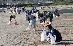 漂着油の除去作業を行う住民ボランティアら＝１８日、奄美市名瀬の知名瀬海岸