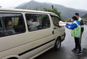 規制区間の入り口で通行証を受け取る認定ガイドの車両＝２２日、奄美市名瀬知名瀬