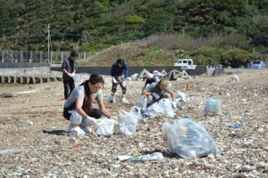 浜辺で油の回収を進める住民ボランティア＝１８日、奄美市笠利町の海岸