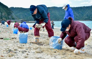 油の回収を行う県職員ら＝８日、奄美市名瀬の朝仁海岸