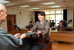 １年間織り技術を学び修了証書を受け取る修了生＝２８日、奄美市名瀬