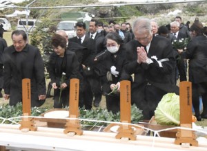 祭壇に献花して犠牲者のみ霊を慰める参列者＝７日、伊仙町犬田布岬