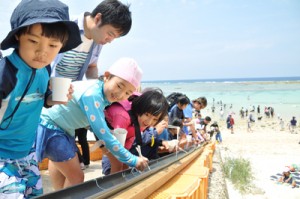 海岸でそうめん流しを楽しむ参加者ら＝２８日、和泊町のワンジョビーチ