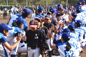 試合後、両チームの選手らからタッチを交わした小学生ら＝２８日、名瀬運動公園市民球場