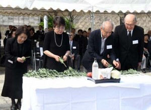 祭壇に献花して犠牲者のみ霊を慰める遺族ら＝２０日、徳之島町亀徳