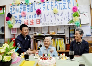 家族や施設職員、仲間に見守られて１０６歳の誕生日を迎えた大里アキさん（中央）＝２５日、和泊町国頭