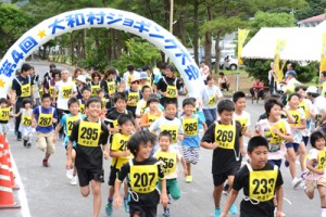 一斉にスタートを切った２キロコースの参加者ら＝２７日、大和村の村体育館前