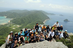 大山・ミヨチョン岳の絶景を背景に記念撮影する参加者＝２日、瀬戸内町請島