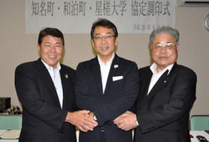 連携協定を結び、固く握手を交わす（左から）今井町長、井上学長、伊地知町長＝９日、知名町