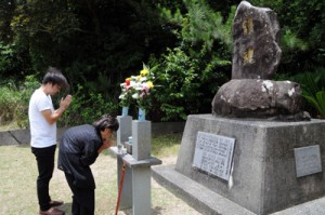 慰霊碑に手を合わせる栫静さん（右）＝２３日、瀬戸内町三浦