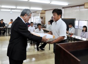 修了生２人に修了証書を手渡し、新たな研修生２人を紹介した修了・入所式＝５日、奄美市役所