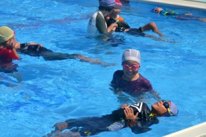着衣水泳を体験する茶花小の児童＝１３日、与論町