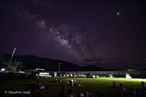 寝転がって星空を眺める来場者＝１５日、瀬戸内町西阿室（荒木マサヒロさん提供）