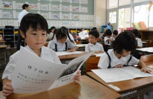 初めての通知表を見つめる小学１年生＝２０日、奄美市の名瀬小学校