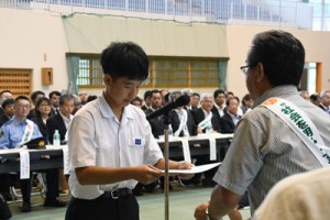 一日保護観察所長の委嘱状を受け取る中村さん（左）＝３日、奄美市住用町