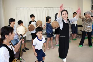 島唄に合わせてチヂン（太鼓）をたたく子どもたち＝２８日、鹿児島市