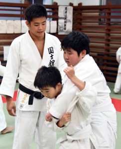 子どもたちに投げ込みを教える前山さん＝２８日、奄美市の名瀬公民館伊津部分館