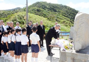 対馬丸慰霊祭で献花する宇検集落の津田正廣区長ら＝２６日、宇検村宇検の船越海岸