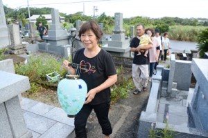 ちょうちんを手に墓参し、先祖の霊を送る人々＝２５日、奄美市笠利町平