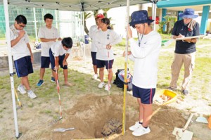 発掘調査に取り組む古仁屋高校の生徒ら＝５日、瀬戸内町