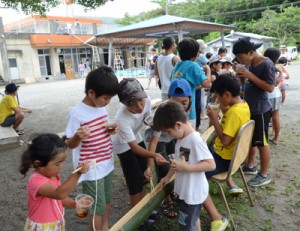 巨大そうめん流しを楽しむ子どもたち＝１２日、奄美市名瀬浦上町