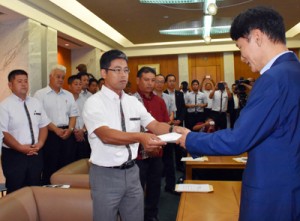 三反園知事に要請書を渡す管野氏（中央）＝６日、鹿児島市の県庁