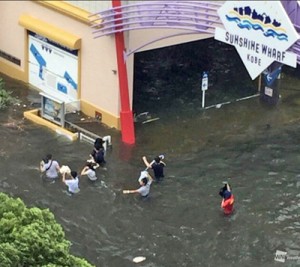 腰まで水に漬かりながら避難する住民＝４日午後、神戸市（提供写真）