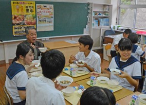 伊集院村長と県産黒毛和牛を使った給食を味わう生徒＝４日、大和村の大和中学校