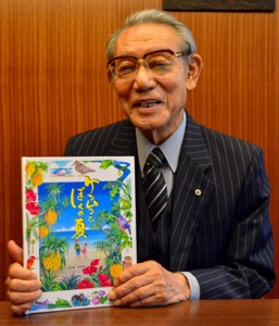 完成した絵本「ケンムンとぼくの夏」を手にする渡会長