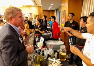 来場者へ奄美黒糖焼酎の説明をする蔵元＝５日、米国ロサンゼルスのミヤコハイブリッドホテル（写真提供・ＬＡ焼酎会）
