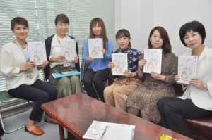 冊子制作に携わったスタッフら＝１１日、奄美市名瀬の南海日日新聞社