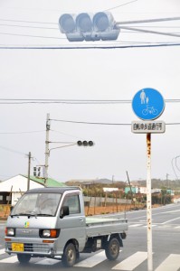 停電で信号が消えた交差点を慎重に通る車＝４日、和泊町