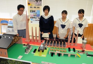 製作した復元模型を前に、久慈の白糖製造工場について説明する生徒＝２２日、瀬戸内町の県立古仁屋高校