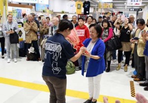 花束贈呈などでツアー客を歓迎したセレモニー＝１８日、天城町の徳之島空港